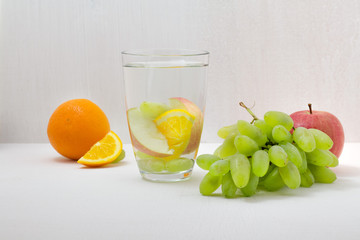 water detox with fruit: apple, orange and grapes