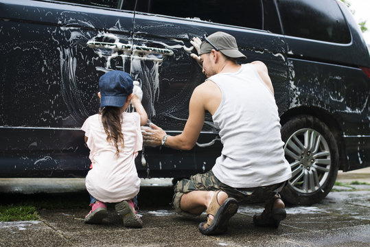 Father and daughter washing the car