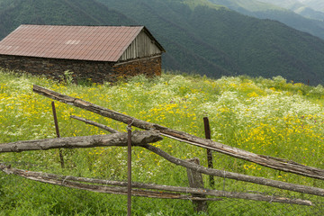 view of an abandoned cabin and the mountains of the Tusheti village of Bochorna