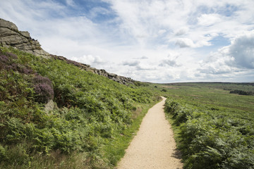 Beautiful vibrant landscape image of Burbage Edge and Rocks in Summer in Peak District England