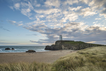 Fototapeta na wymiar Stunning Summer landscape image of lighthouse on end of headland with beautiful sky