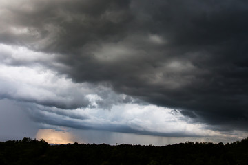 Dark storm clouds over meadow with green grass
