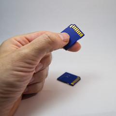 man hand holding a memory card on a white background.