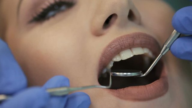 Doctor doing dental treatment to his patient in clinic