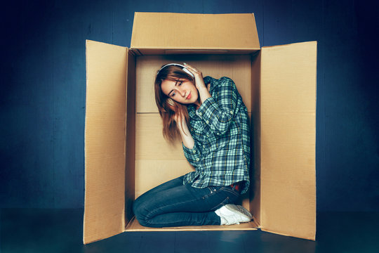 Introvert Concept. Woman Sitting Inside Box And Working With Laptop