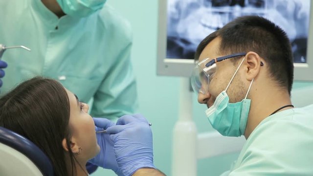 Doctor doing dental treatment to his patient in clinic