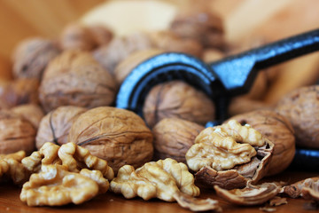 Walnuts and unshelled walnuts with nutcracker.