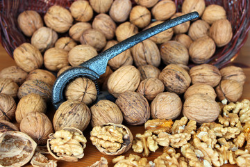 Walnuts and unshelled walnuts with nutcracker.