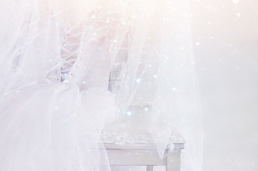 Naklejka na ściany i meble Beautiful white wedding dress and veil on chair