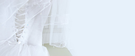 Beautiful white wedding dress and veil on chair