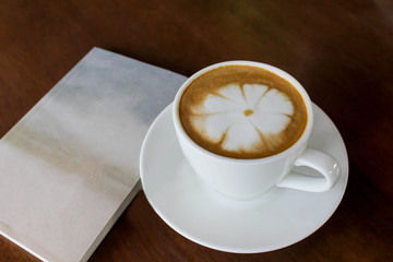 Hot coffee in white cup on wooden background