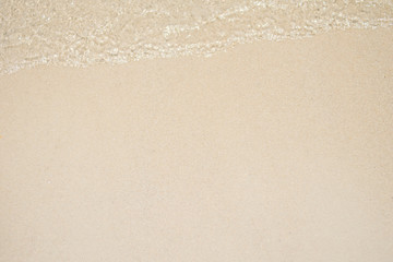 sea water waves with bubbles on sand beach