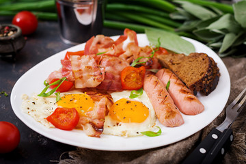 English breakfast - fried egg, sausage, tomatoes, bacon and toast.