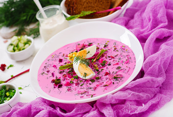 Cold beetroot (beet) soup on yogurt with egg, onion and cucumbers.