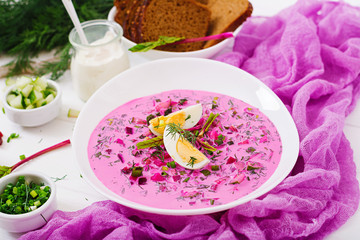 Cold beetroot (beet) soup on yogurt with egg, onion and cucumbers.