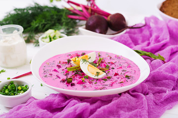 Cold beetroot (beet) soup on yogurt with egg, onion and cucumbers.