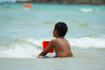 boy playing on the beach in the water