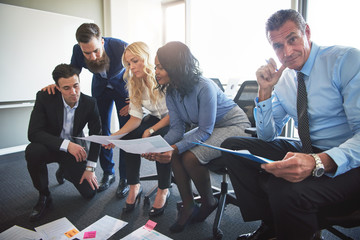 Corporate professionals discussing paperwork together in an office