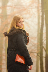 Woman walking in park in foggy day