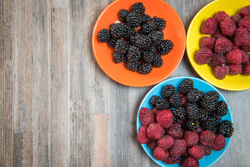 Fresh berries blackberry and raspberry on a plate in vintage style