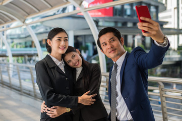 Asian business team  taking a selfie with smartphone in the city