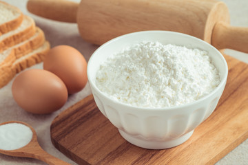 Fototapeta na wymiar Flour in bowl with eggs and bread
