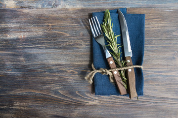 Simple laconic design cutlery on linen napkin on rustic wooden table. Concept of natural organic...