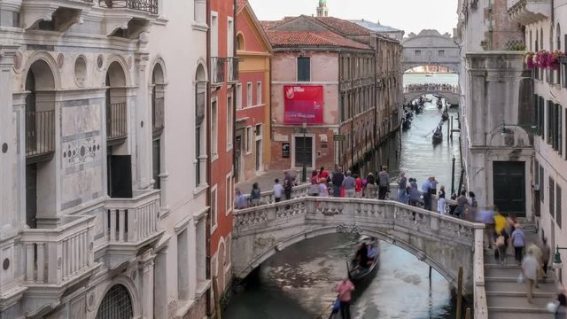 Gondolas travel along a busy canal in Venice Italy.