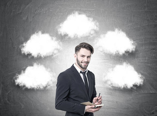 Cheerful businessman with a planner, thought clouds