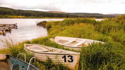 Unlucky number thirteen rowing boat full of water beside reservoir