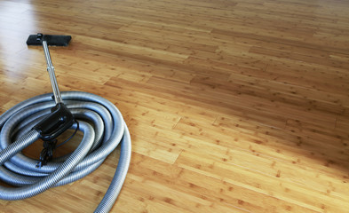 Beautiful bamboo hardwood floor with a central vacuum cleaner. Cleaning contest. 