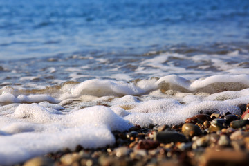 Waves washing over gravel beach, macro shot.