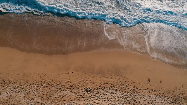 Aerial top shot of sandy golden beach waves and turquoise ocean. Perfect for wordpress website video background or nature travel video