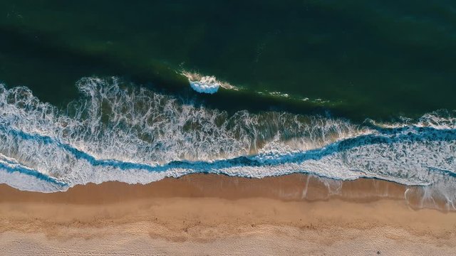 Aerial top shot of sandy golden beach waves and turquoise ocean. Perfect for wordpress website video background or nature travel video