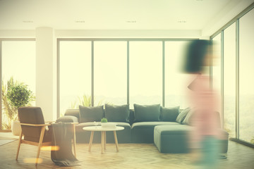 White living room interior with a gray sofa, girl