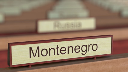 Montenegro name sign among different countries plaques at international organization. 3D rendering