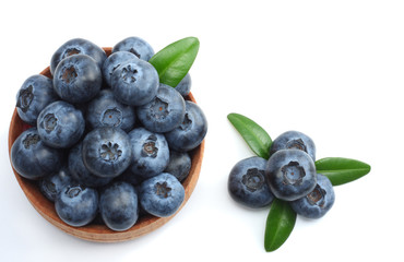 blueberries in wooden bowl isolated on white background