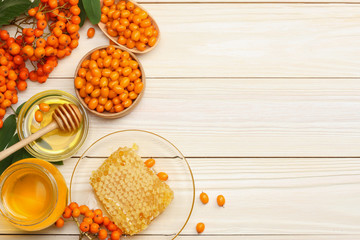 Sea buckthorn in wooden bowl, honey, Sea buckthorn juice on wooden table. top view with copy space