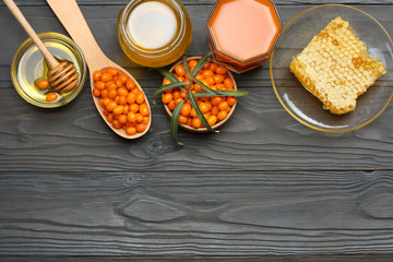Sea buckthorn in wooden bowl, honey, Sea buckthorn juice on wooden table. top view with copy space