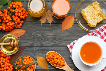Sea buckthorn in wooden bowl, honey, Sea buckthorn juice on wooden table. top view with copy space