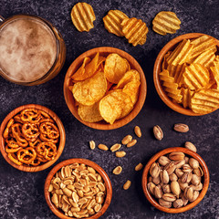 Beer with snacks on stone background.