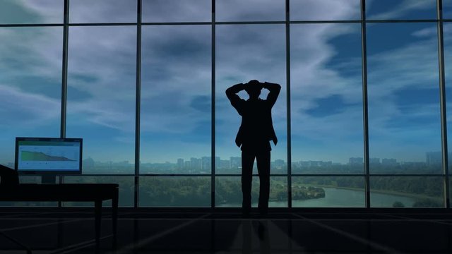 A businessman holds his head in his office when thunderclouds gather around him