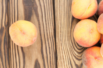 Heap of fresh whole ripe peaches and one peach separately on rustic old wooden planks