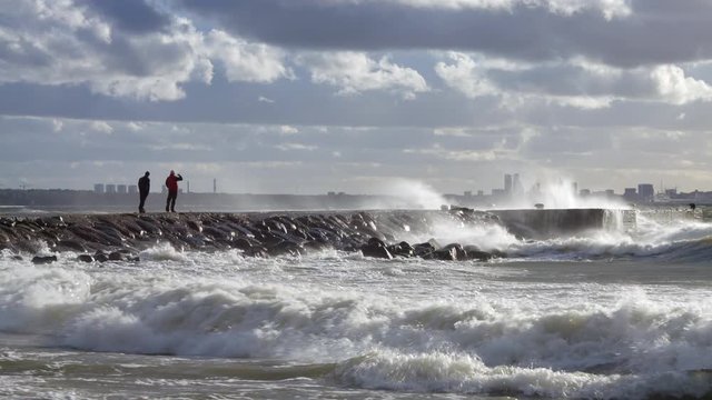 man takes photos of big white storm waves