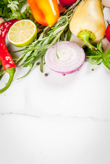 Food cooking background, white marble table. Fresh raw organic vegetables (tomatoes, peppers, mushrooms, onion), herbs, spices, lime for preparation dinner. Top view copy space
