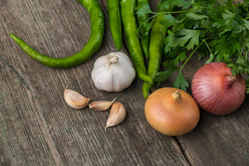 Onion, corn, garlic, pepper, coriander and parsley on an old wooden board