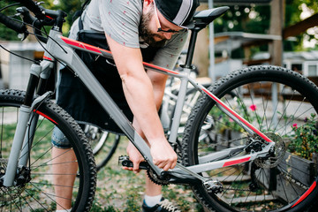 Fototapeta na wymiar Bicycle mechanic hands adjusts cycling pedals