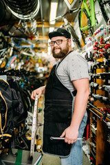 Obraz premium Bicycle mechanic with wheel in bike shop