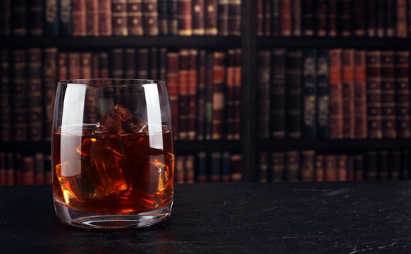 whiskey with ice in glass on a dark background