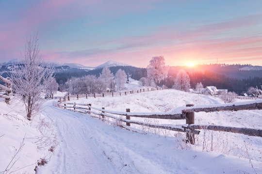 Winter country landscape with timber fence and snowy road